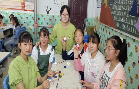 图为实践团成员刘絮和河东寄宿制学校的同学们一起绘制惠山泥人